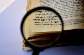 Magnifying glass over the word "strategy" in the dictionary