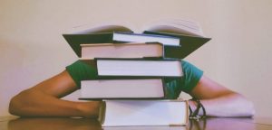 Girl hiding behind books